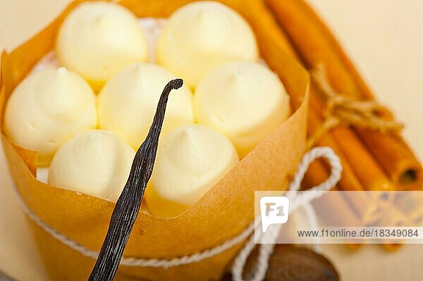 Frische Vanille- und Gewürzsahnetorte als Dessert auf einem rustikalen weißen Holztisch
