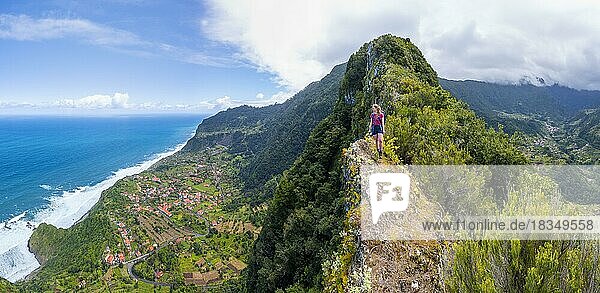 Wanderin am Grat des Pico do Alto  Blick über Küstenlandschaft  Ort Arco de Sao Jorge  Madeira  Portugal  Europa