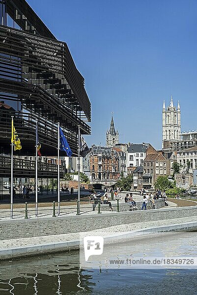 Young people in front of the public library De Krook  and view over the belfry and St Bavo Cathedral towers in the city Ghent  East Flanders  Belgium  Europe