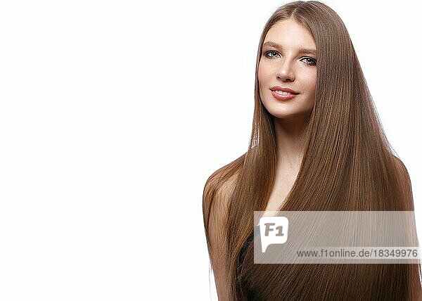 Beautiful brown-haired girl with a perfectly smooth hair  and classic make-up. Beauty face and hair. Picture taken in the studio on a white background