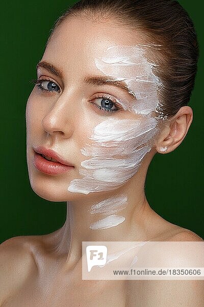 Schönes frisches Mädchen mit kosmetischer Creme auf dem Gesicht  natürliches Make-up. Schönes Gesicht. Foto im Studio aufgenommen