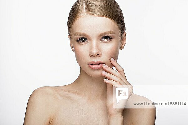 Beautiful young girl with a light natural make-up and French manicure. Beauty face. Picture taken in the studio on a white background