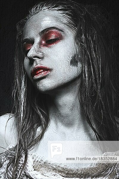 Mädchen in Form von Zombies  Halloween-Leiche mit Blut auf den Lippen. Bild für einen Horrorfilm. Fotos im Studio aufgenommen