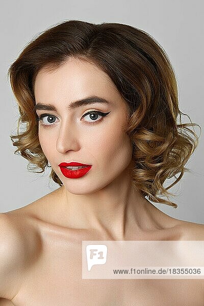 Beauty-Porträt von hübschen Mädchen mit lockigem Haar  Katzenaugen-Make-up  rote Lippen. Schönheit  Kosmetik-Konzept. Gesundheitswesen