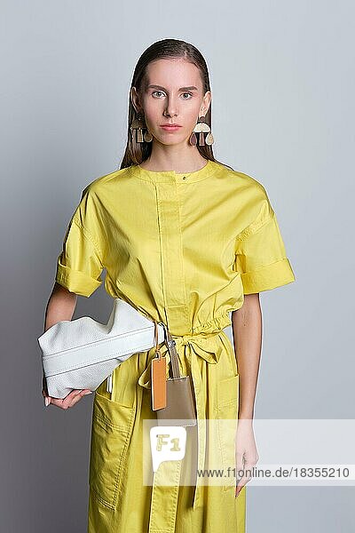 Niedliches Mädchen in gelbem Kleid mit Handtasche