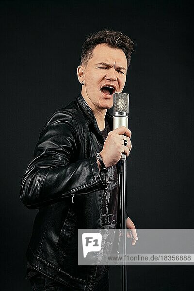 Unauffälliges Porträt eines singenden Mannes mit Mikrofon in der Hand