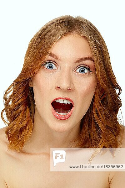 Portrait of surprised young woman with wide open mouth. Blue eyes and red lips. Beauty portrait  fresh skin. Natural makeup