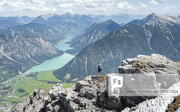 Wanderin an einer Felskante  Ausblick vom Thaneller auf den Plansee und östliche Lechtaler Alpen  Tirol  Österreich  Europa
