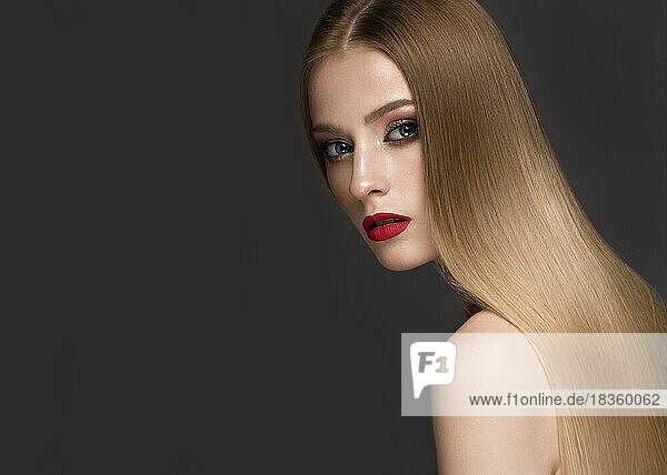 Schönes blondes Mädchen mit perfekt glattem Haar  klassischem Make-up und roten Lippen. Schönes Gesicht. Bild im Studio auf einem weißen Hintergrund genommen