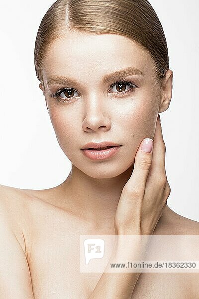 Schönes junges Mädchen mit einem leichten natürlichen Make-up und französischer Maniküre. Schönes Gesicht. Bild im Studio auf einem weißen Hintergrund aufgenommen