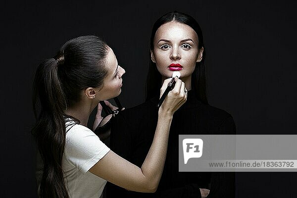 Zwei schöne Mädchen auf einem Foto-Shooting zu schminken  um das Gesicht. Schönheit Mode-Modell. Fotos im Studio geschossen