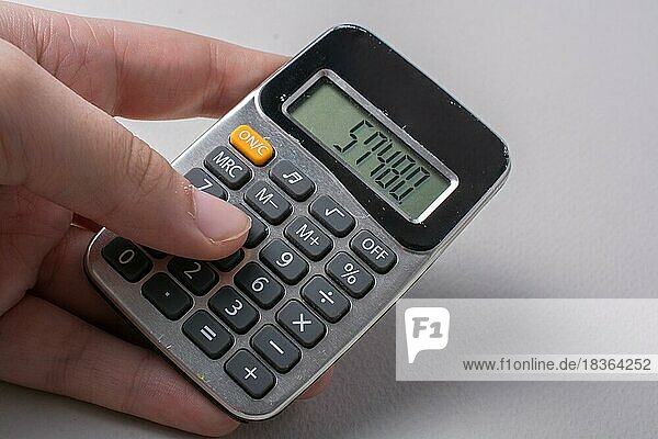 Hand holding a calculator in hand on white