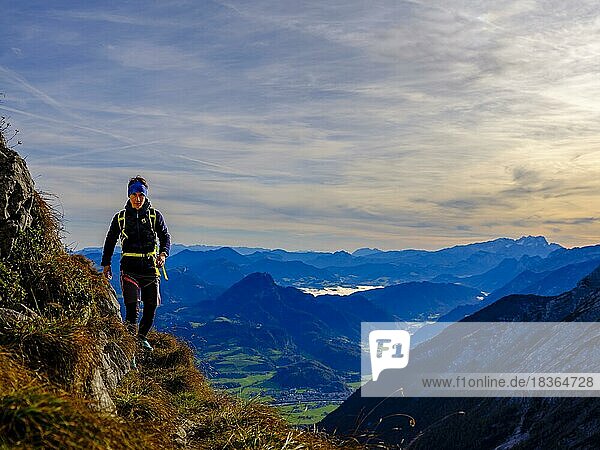 Mountaineer walking on a narrow path above the Salzach valley  in the background Osterhorn group and Hoher Dachstein  Golling  Salzburger Land  Austria  Europe
