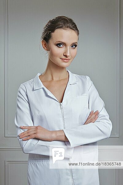 Schöne Ärztin in weißer Kleidung. Porträt einer attraktiven Ärztin in weißem Gewand