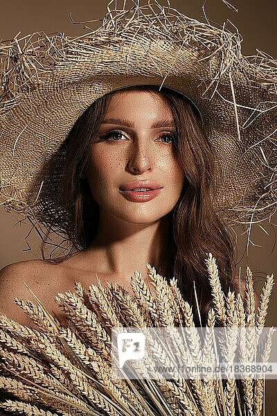 Portrait of a beautiful woman in a straw hat  loose hair and nude makeup. Beauty face
