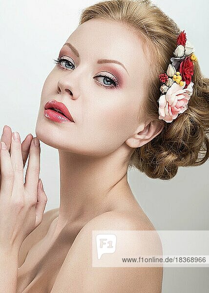 Portrait of a beautiful girl with pink flowers on her head. Photo shot in the Studio on a white background