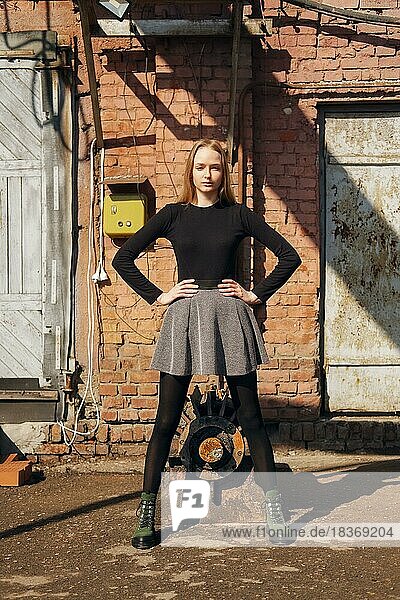 Hübsches Modell posiert auf alten Fabrik Hinterhof stehen gerade und legte ihre Beine breit