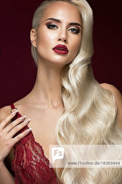 Schöne Blondine in einer Hollywood-Manier mit Locken  roten Lippen  roten Dessous. Schönes Gesicht und Haare. Bild im Studio aufgenommen