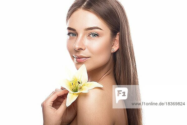 Schönes junges Mädchen mit einem leichten natürlichen Make-up und perfekter Haut mit Blumen in der Hand. Schönes Gesicht. Bild im Studio auf einem weißen Hintergrund aufgenommen