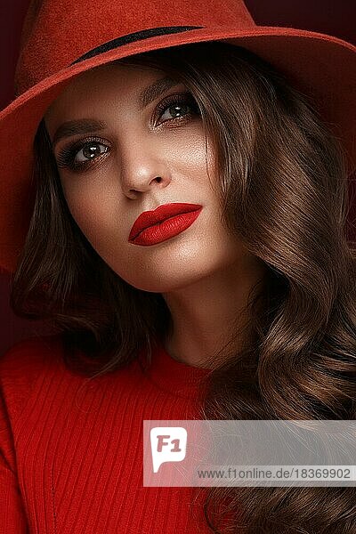 Schöne sexy Frau in einem modischen Hut  mit klassischem Make-up  Wellenhaar und roten Lippen. Schönes Gesicht. Foto im Studio aufgenommen