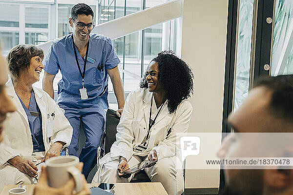 Fröhliches multirassisches Gesundheitspersonal während der Kaffeepause im Krankenhaus