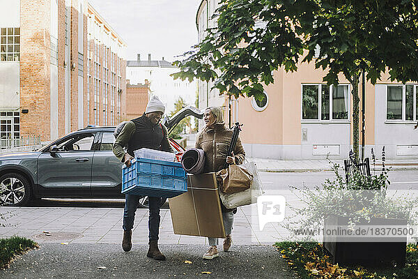 Älteres Paar mit Gepäck  das gemeinsam auf einem Fußweg spazieren geht