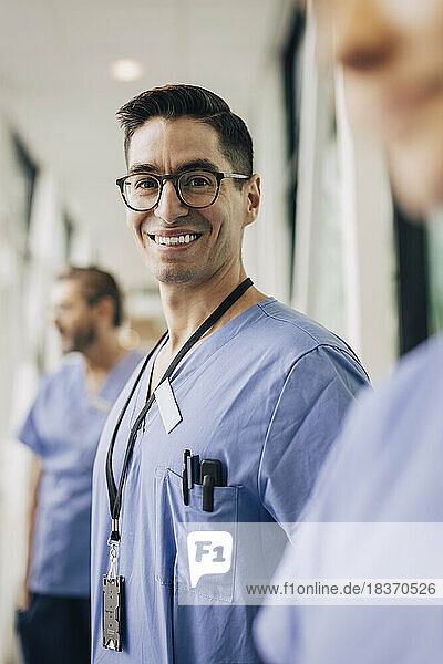 Porträt eines glücklichen männlichen Pflegepersonals mit Brille im Krankenhaus