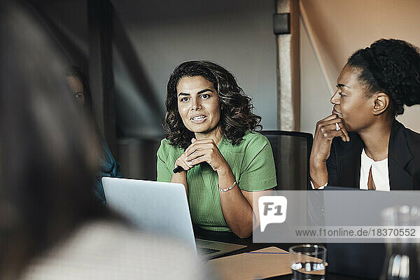 Reife Geschäftsfrau  die in einer Sitzung mit weiblichen Kollegen im Büro diskutiert