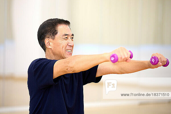 Japanese senior man training at indoor gym