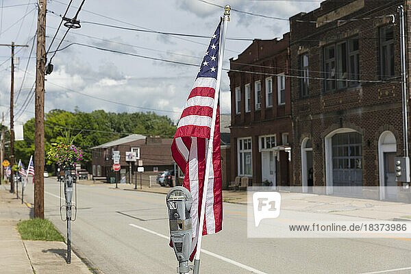 American flag fluttering in the breeze on a deserted main street.