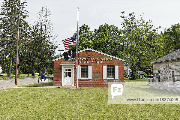 Rural US post office building  with an American flag flying.