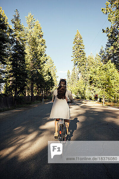 USA  California  Tahoe City  Rear view of woman riding bicycle on road