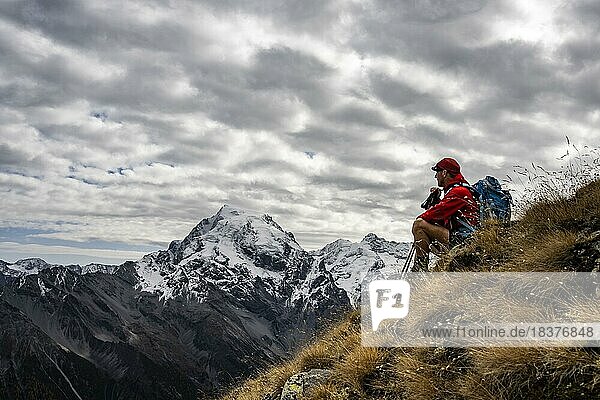 Mountaineer on autumnal mountain meadow with cloudy sky in front of Ortler summit massif  Trafoier Tal  Merano  Vinschgau  South Tyrol  Italy  Europe