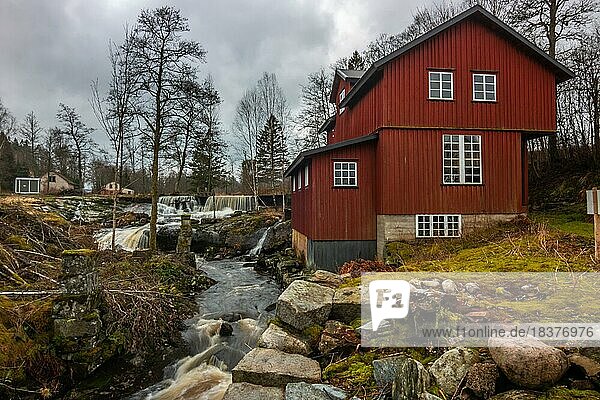 Typische rote Häuser  eine ehemalige verlassene Mühle am einem Fluss in Schweden