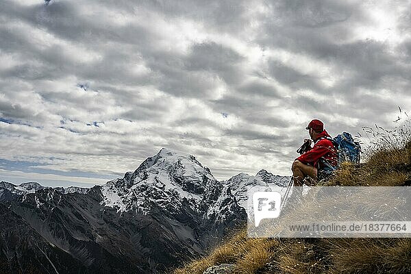 Mountaineer on autumnal mountain meadow with cloudy sky in front of Ortler summit massif  Trafoier Tal  Merano  Vinschgau  South Tyrol  Italy  Europe