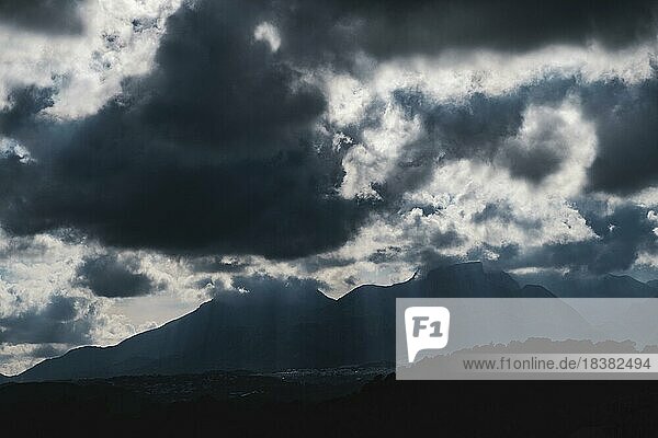 Dramatischer Himmel mit riesigen dunklen Wolken über zerklüfteten Bergsilhouetten in Spanien