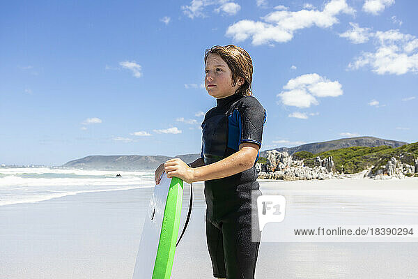 9 year old boy in wetsuit body boarding Grotto Beach Hermanus South Africa