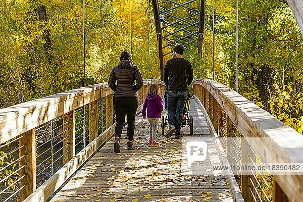 family crosses bridge in fall near Sun Valley Idaho