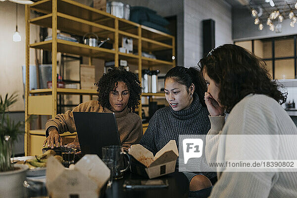 Multirassische Programmiererinnen diskutieren am Laptop bei der Arbeit in einem Startup-Unternehmen