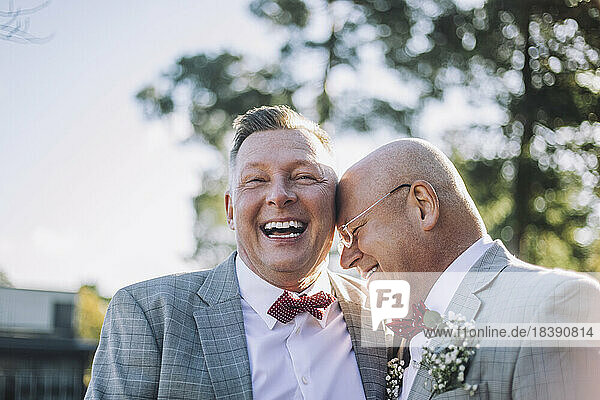 Fröhliches  frisch verheiratetes schwules Paar lacht zusammen bei der Hochzeit