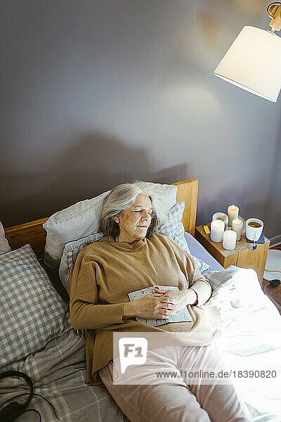 Hohe Winkel Ansicht der älteren Frau schlafen  während liegend auf dem Bett zu Hause