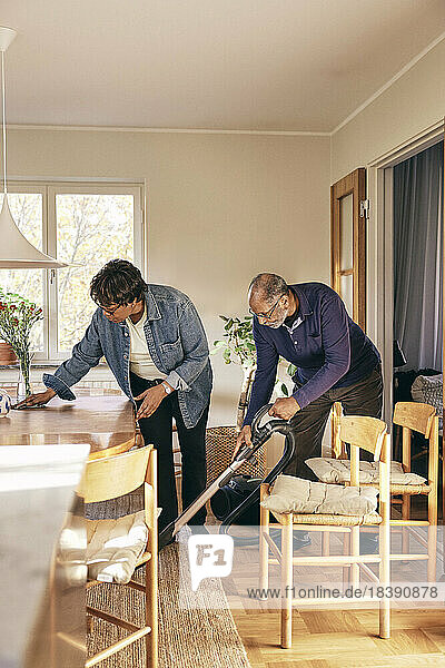 Älteres Ehepaar hilft sich gegenseitig beim Hausputz