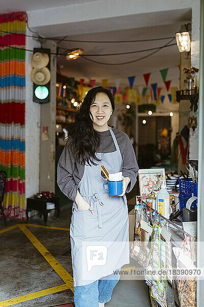 Portrait of confident female restaurant owner standing with hand in pocket