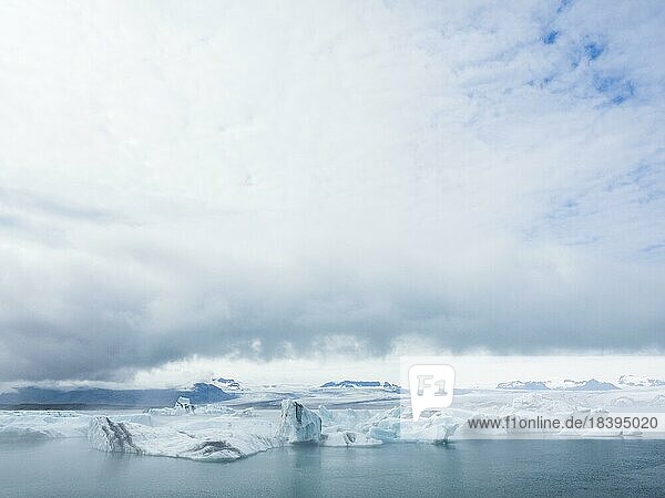 Dunkle Wolken über der Gletscherlagune  Eisberge schwimmen in der Gletscherlagune Jökulsarlon  Vatnajökull-Nationalpark  Hornafjörður  Südisland  Island  Europa
