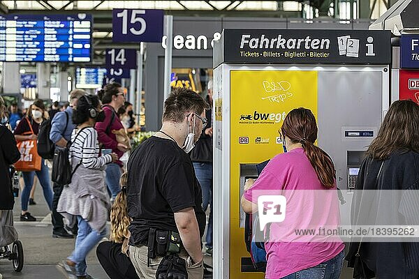 Viele Menschen auf Reisen  im Hauptbahnhof warten sie auf ihren Zug  eine Frau löst am Ticket-Automat einen Fahrschein  Stuttgart  Baden-Württemberg  Deutschland  Europa