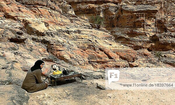 Aufstieg zum Kloster Ad-Deir  Frau beim Teekochen an einem einsamen Lagerfeuer in der felsigen  verlassenen Stadt Petra  al-Batra  Hauptstadt des Königreichs der Nabatäer  Jordanien  Asien