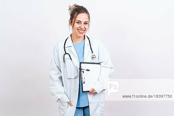 Glückliche schöne Ärztin in medizinischem Kittel stehend vor weißem Hintergrund  Medizin Konzept