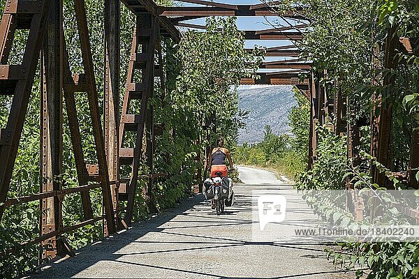 Cycling over old bridge on the Ciro Trail  bicycle route from Dubrovnik to Mostar along discontinued railway line  southwestern Bosnia and Herzegovina