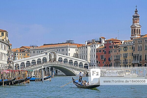 Ponte di Rialto Bridge over the Grand Canal  Canal Grande and gondolier in traditional gondola with tourists in Venice  Veneto  Northern Italy