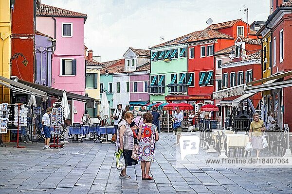 Ältere einheimische Frauen beim Einkaufen auf einem Platz mit bunten Restaurants auf Burano  einer Insel in der Venezianischen Lagune in der Nähe von Venedig  Venetien  Norditalien